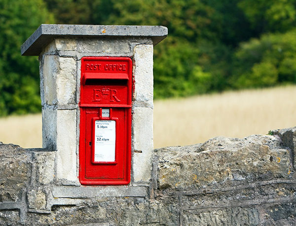 Photo of small red postbox set flush into wall